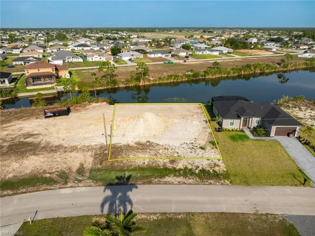 Aerial perspective of suburban area with property boundaries highlighted and a nearby body of water