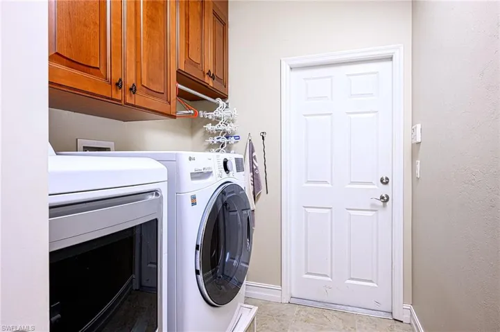 Laundry room with cabinets and independent washer and dryer on stands