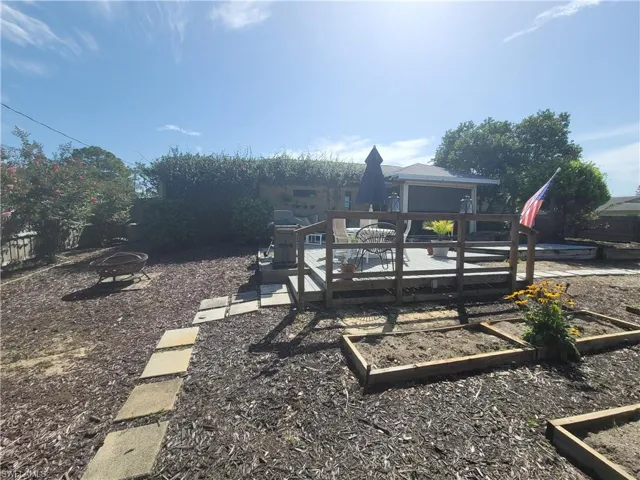 View of yard with an outdoor fire pit and a wooden deck