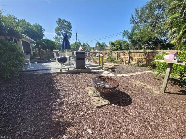 View of yard with a deck and an outdoor fire pit