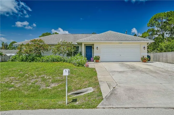 Ranch-style home with a front yard and a garage