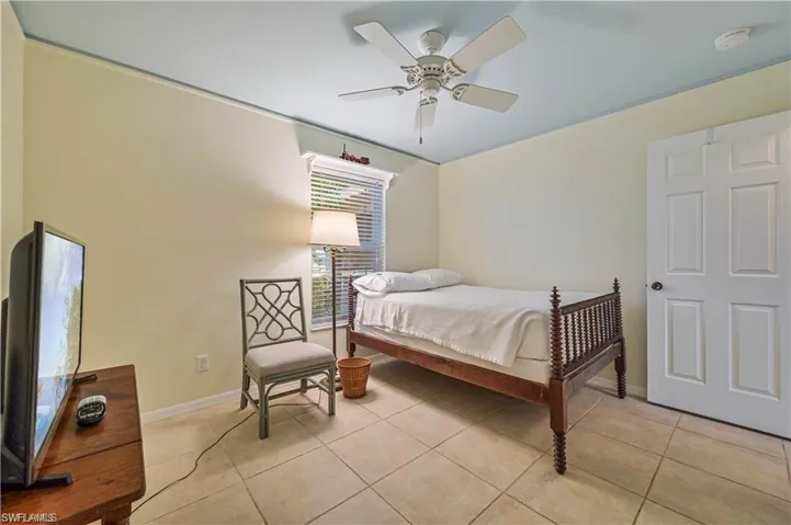 Bedroom with ceiling fan and light tile patterned flooring