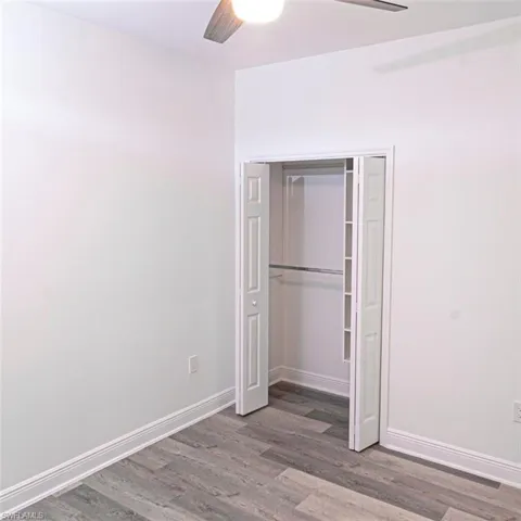 Room featuring wood-finish flooring, white baseboards, and neutral wall tones