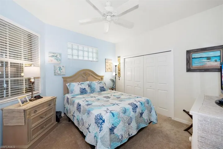 Carpeted bedroom featuring a ceiling fan and a closet