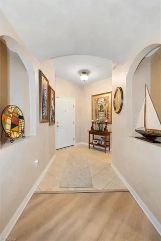 Foyer entrance featuring arched walkways and light wood-style flooring