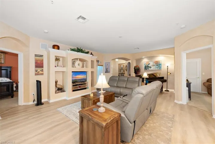 Living room with arched walkways and light wood-style flooring