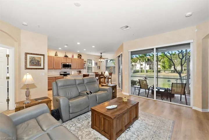 Living area featuring a water view, light wood-type flooring, a ceiling fan, and recessed lighting