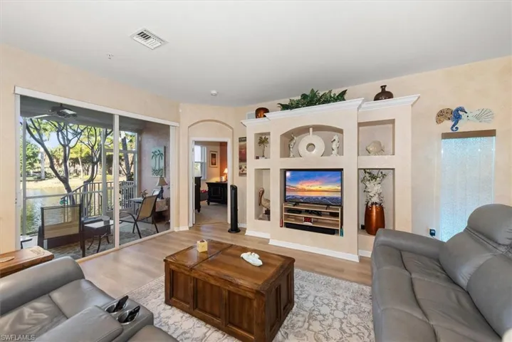 Living room featuring light wood finished floors, arched walkways, and ceiling fan