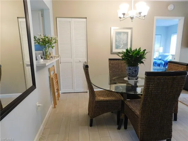 Dining area with hanging lights and light wood-type flooring