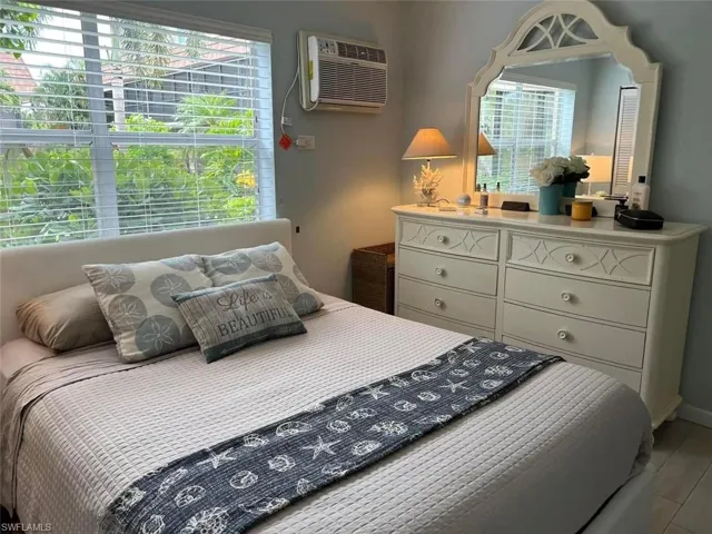 Bedroom featuring a wall mounted air conditioner and wood finished floors