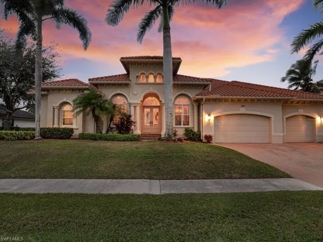 Mediterranean / spanish house featuring a garage and a yard