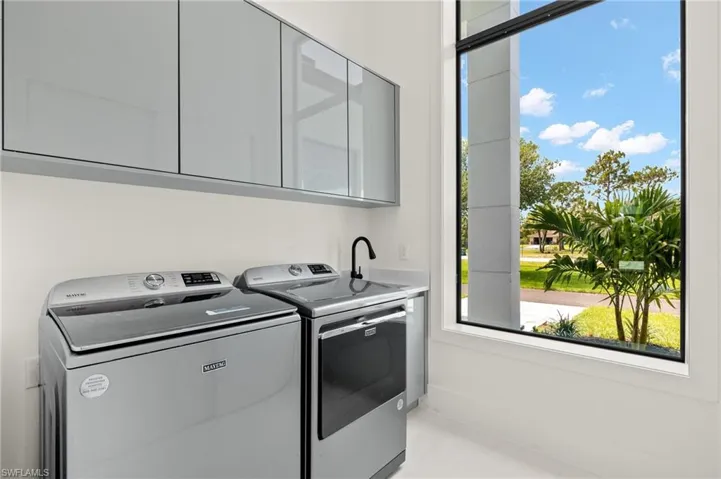 Laundry area with a healthy amount of sunlight, cabinets, and separate washer and dryer