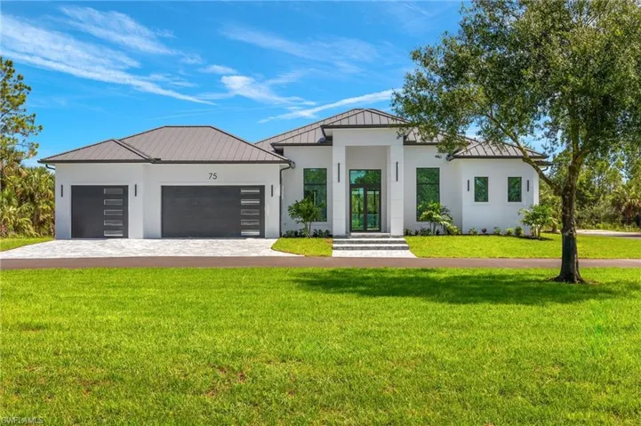 View of front facade featuring a garage and a front yard