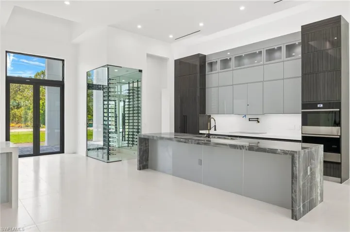 Kitchen with french doors, dark stone countertops, sink, tasteful backsplash, and light tile floors
