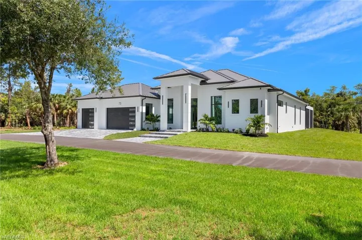 View of front of house with a garage and a front yard