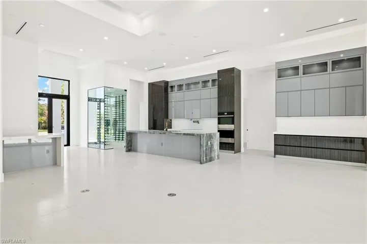 Kitchen with sink, stainless steel double oven, kitchen peninsula, and light tile floors