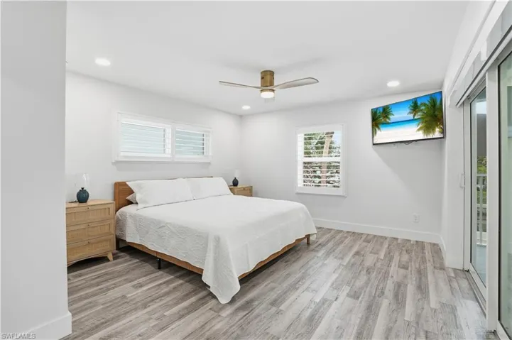 Bedroom with access to outside, ceiling fan, light wood-style flooring, and recessed lighting - Virtually Edited Image