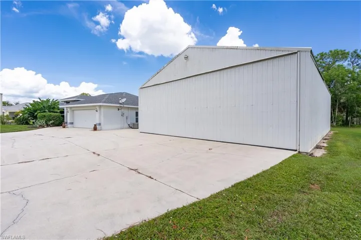 View of side of home with a lawn and a garage