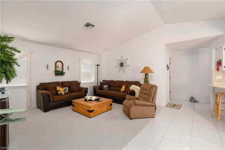 Tiled living room with lofted ceiling