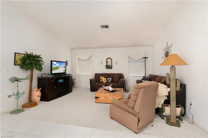 Living room featuring vaulted ceiling and light tile patterned floors