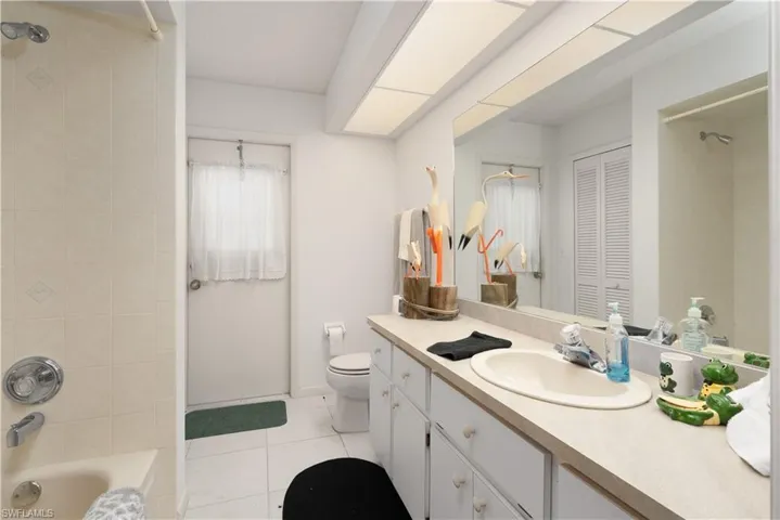 Full bathroom with vanity, tiled shower / bath combo, toilet, and tile patterned flooring** Virtually Staged**