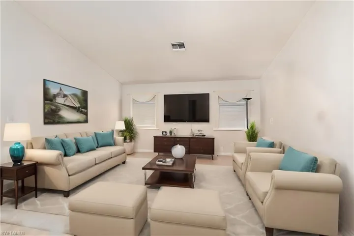 Living room with lofted ceiling and light tile patterned floors** Virtually Staged**