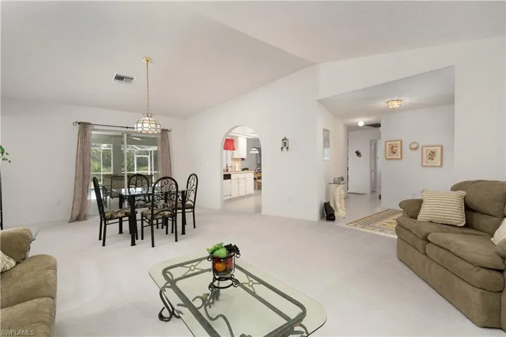 Living room with light carpet and vaulted ceiling