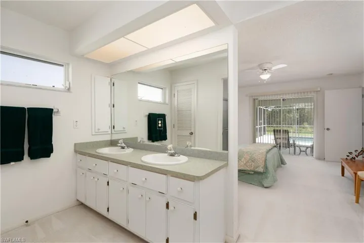 Bathroom featuring ceiling fan and dual vanity