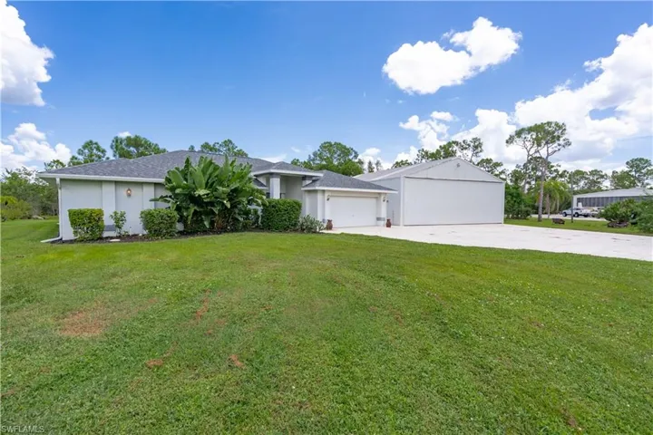 Single story home featuring a garage and a front lawn