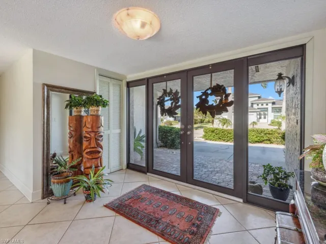 Tiled entrance foyer with a textured ceiling and french doors