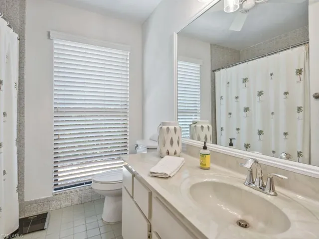 Bathroom with tile patterned flooring, vanity, a shower with shower curtain, and toilet