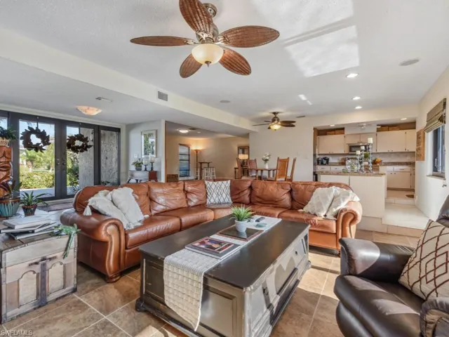 Living room with french doors, a textured ceiling, and ceiling fan