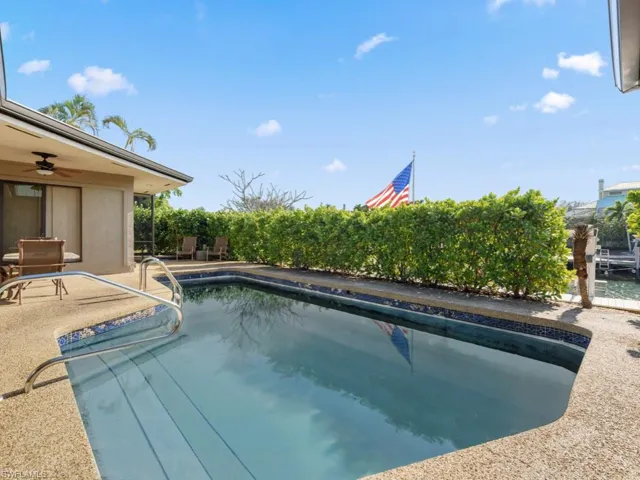 View of swimming pool with ceiling fan and a patio