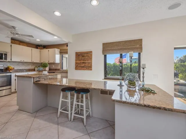 Kitchen featuring light stone countertops, stainless steel appliances, and a textured ceiling