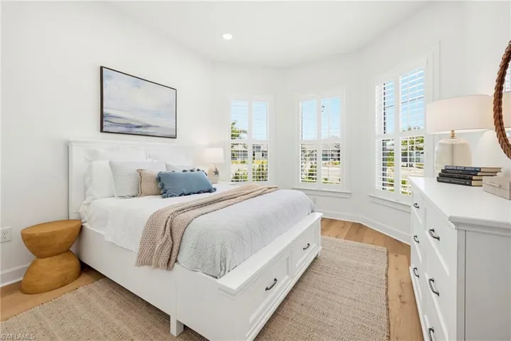 Bright room featuring light wood-finish flooring, white walls, and recessed lighting