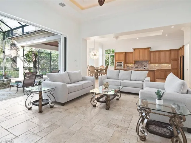 Tiled living room with a towering ceiling, crown molding, and a tray ceiling