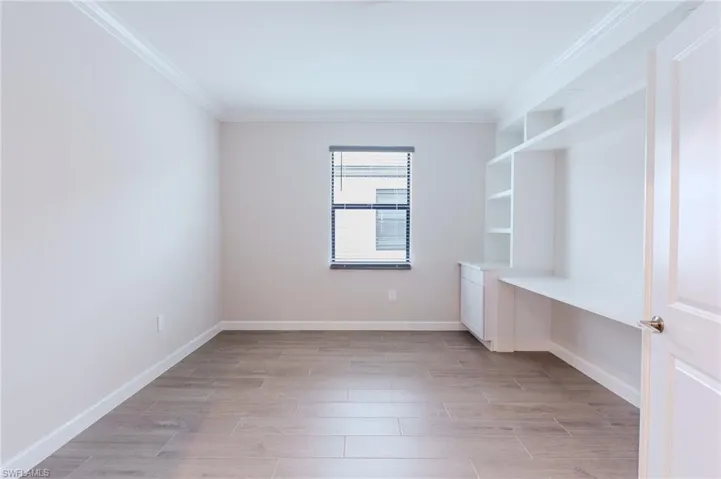 Bedroom with crown molding, access to outside, wood tiled floors, a ceiling fan, and a raised ceiling