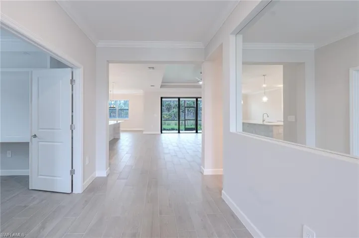 Hallway featuring ornamental molding and light wood-style flooring