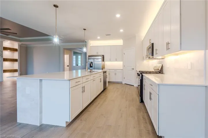 Office area with light wood finished floors, ornamental molding, and built in study area