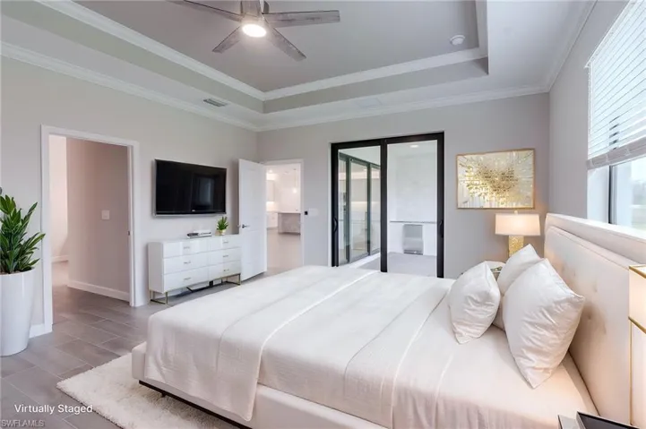 Spare room with wood tiled floors, crown molding, a ceiling fan, and a tray ceiling