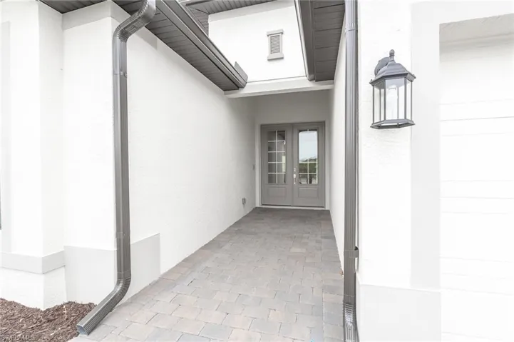 Entrance to property featuring stucco siding and french doors