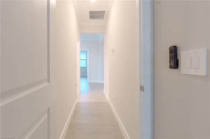 Doorway featuring crown molding and wood finished floors