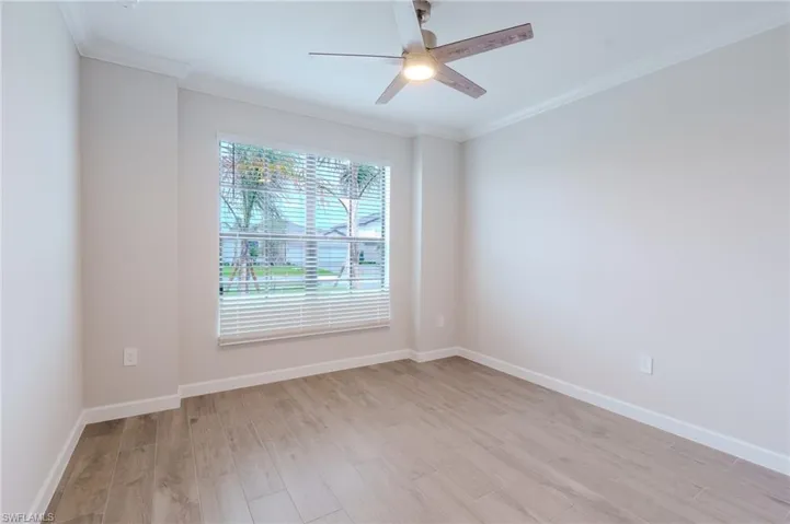 Unfurnished room featuring crown molding, light wood-style floors, and a ceiling fan