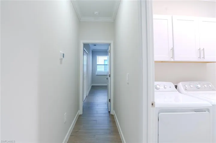 Spare room with crown molding, light wood-style floors, and a ceiling fan