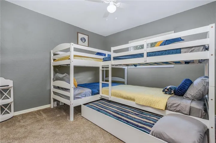 Bedroom featuring light carpet, a textured wall, and ceiling fan