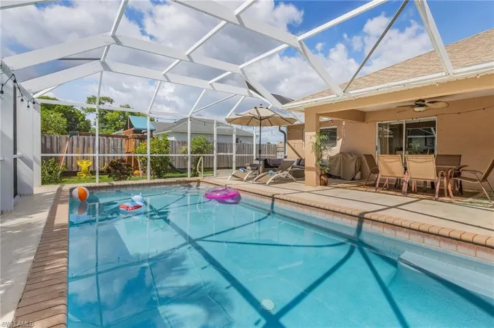 View of pool with a lanai, a patio, a sunroom, and outdoor dining space