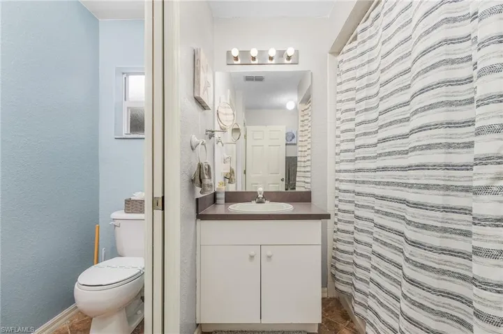 Bathroom featuring vanity, a shower with shower curtain, and a textured wall