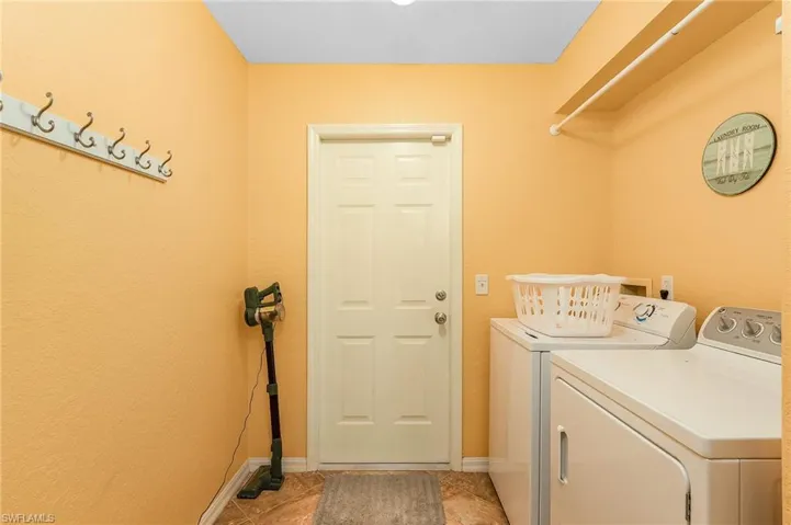 Laundry area featuring washing machine and clothes dryer and baseboards