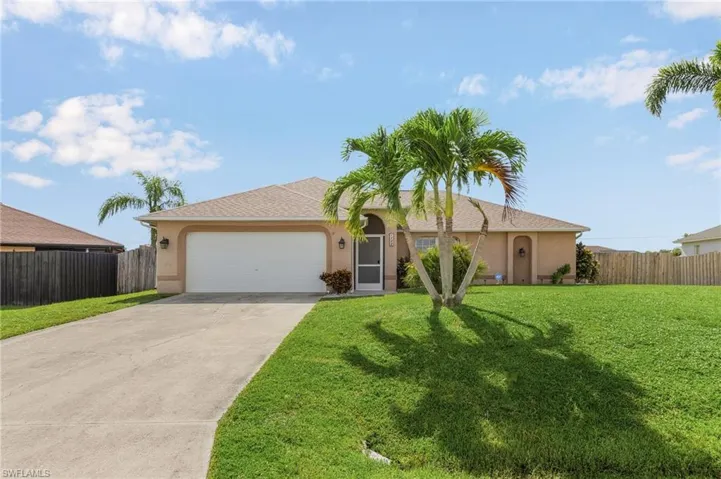 Single story home with driveway, stucco siding, and an attached garage