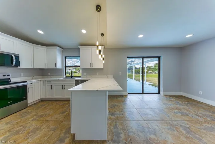 Bright kitchen with adjoining breakfast nook overlooking the pool, perfect for relaxed mornings.